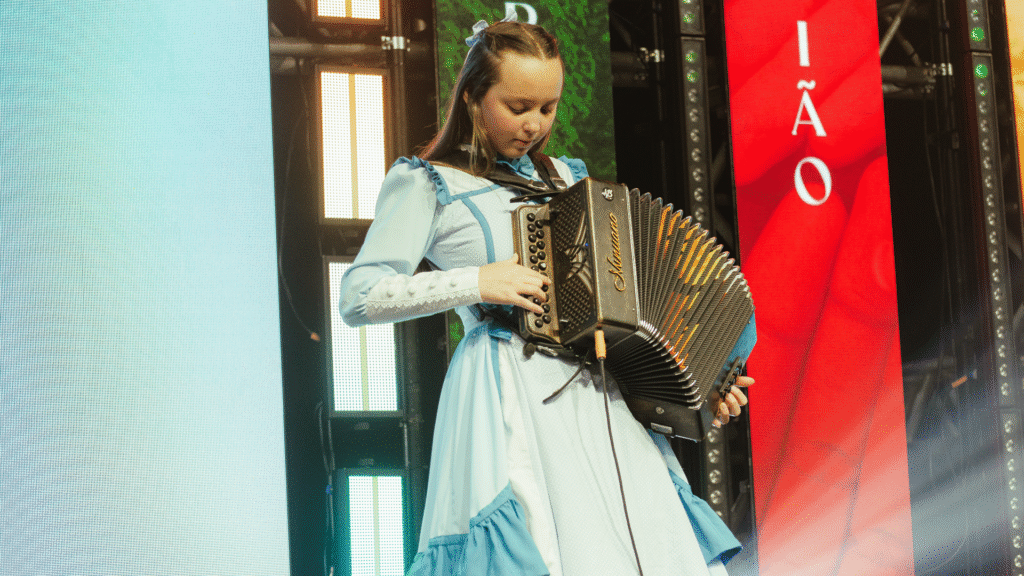 Valentina Morais, do CTG Estância Colorado, toca gaita durante apresentação no 13º Encontro de Produtoras Rurais