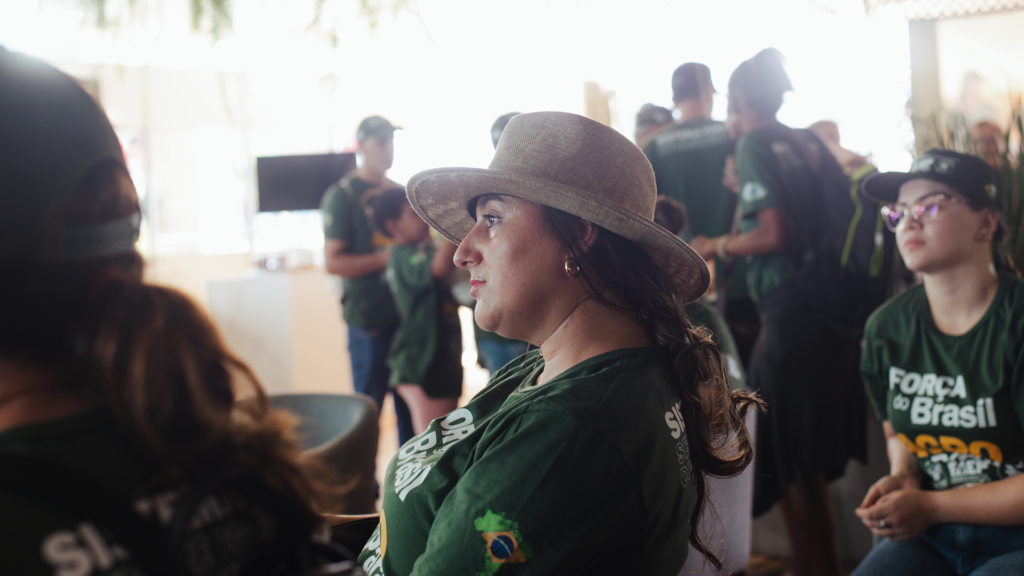 Mulher produtora rural assistindo palestra sobre saúde preventiva no estande do Sistema FAEP